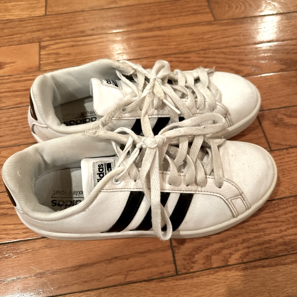 White and black striped adidas shoes.